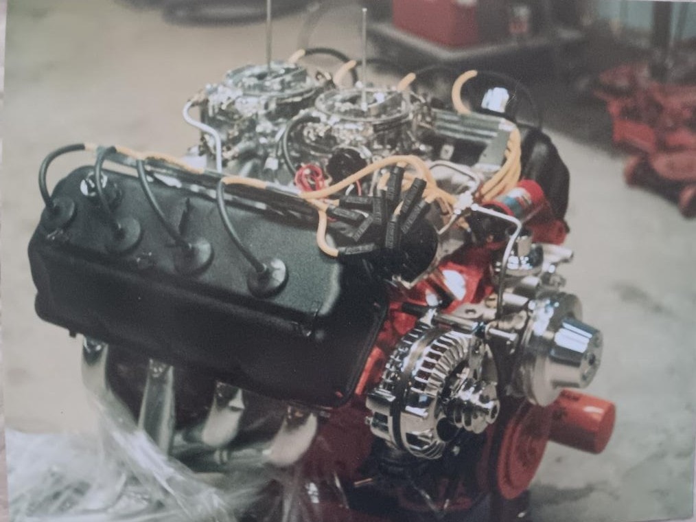 Dan Powell's 426 Super Stock Hemi on the engine stand — dual four-barrel carburetors, black wrinkle rocker covers, chrome accessories, built from a 1966 block to full factory Super Stock specification