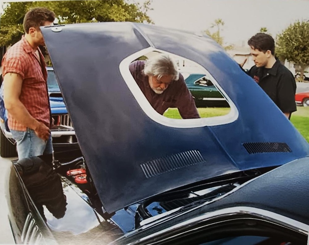 Gunnar Hansen, the lead, and director Nick Palumbo lean over the Black Beast's shaker hood going over the scene — Murder-Set-Pieces set, Las Vegas 2004