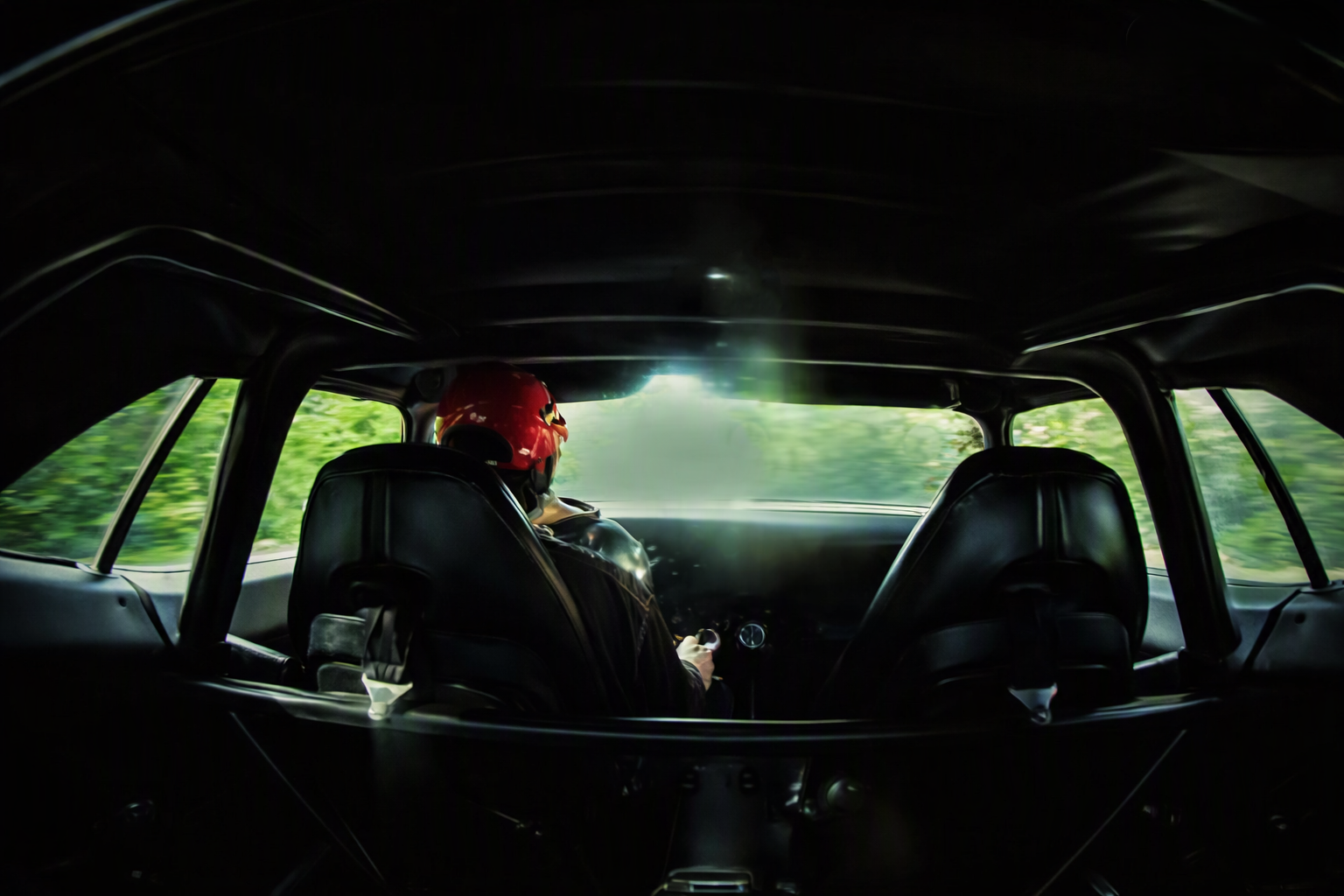 Driver behind the wheel, green road blurring past — a memory of the runs shared with friends now gone
