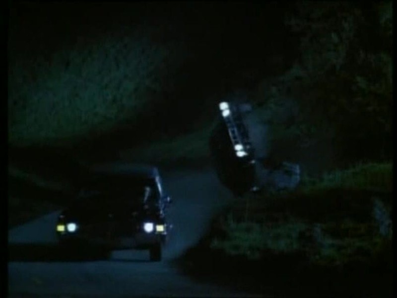 Phantasm III Cuda airborne at night — stunt crash sequence, second vehicle headlights at left