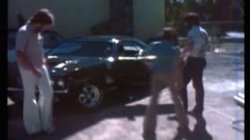 Production crew gathered around the Phantasm I movie car — on-set parking lot