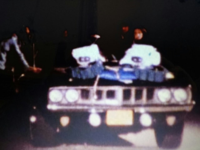 Poor man's process — two figures on the Cuda hood with lighting rigs, driving shot setup, Phantasm I
